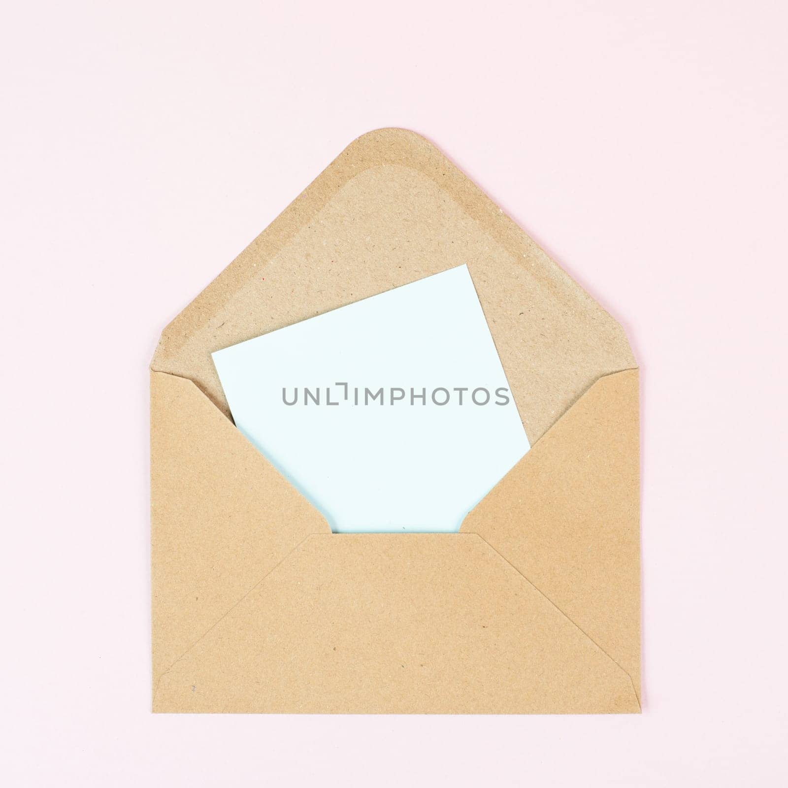 Envelope with an empty paper on a rose colored background, copy space for text, greeting card, communication and announcement concept, reminder