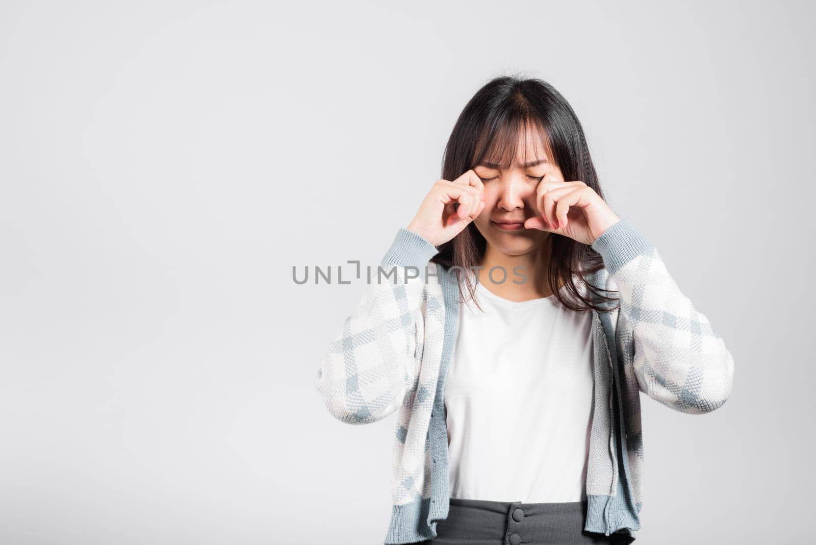 Unhappy woman bad mood her cry wipe tears with fingers, Asian beautiful young female stress feeling sad unhappy crying, studio shot isolated on white background with copy space