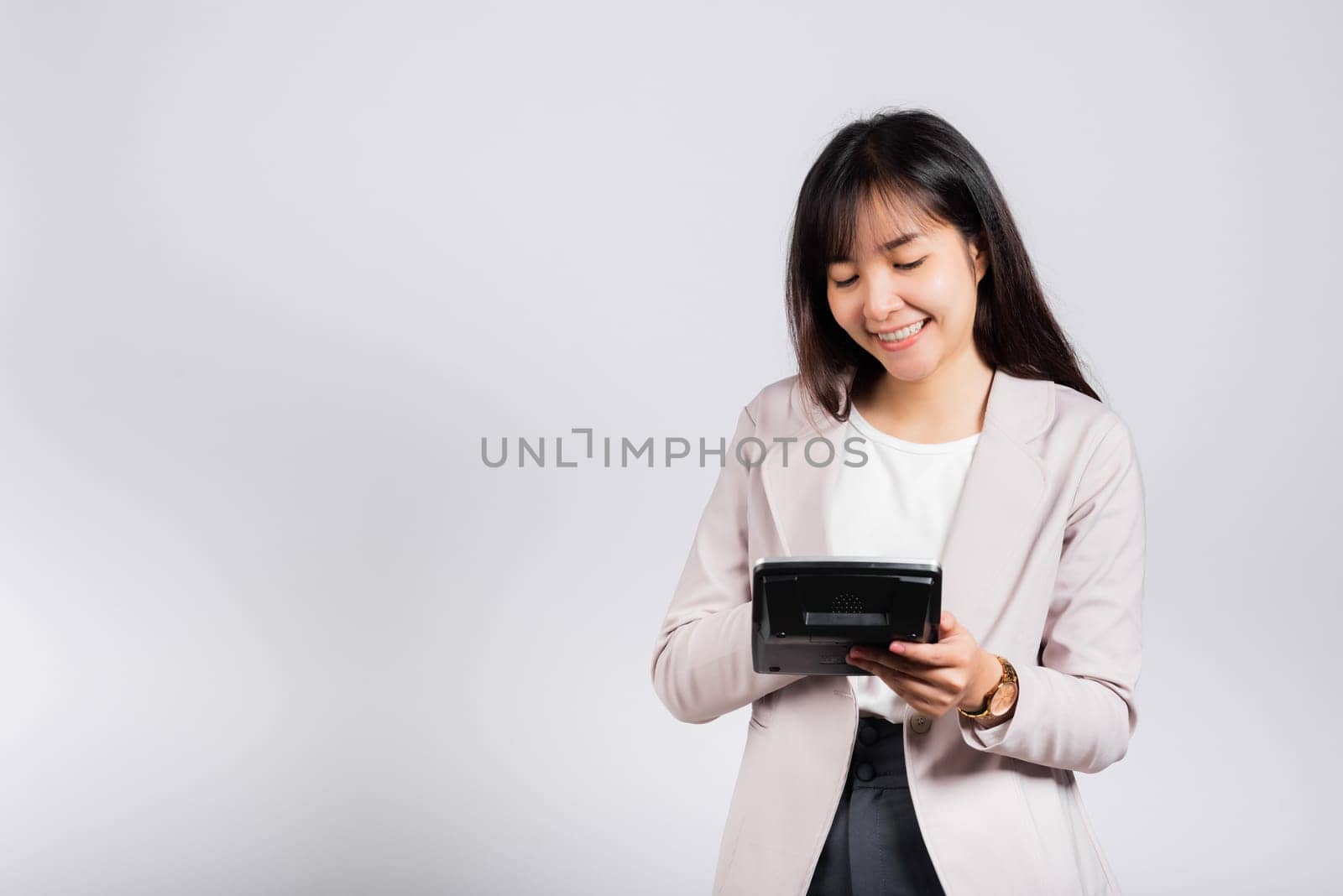 Tax day concept. Woman confident smiling holding electronic calculator, Portrait excited happy Asian young female studio shot isolated on white background, Business Account and finance counting income