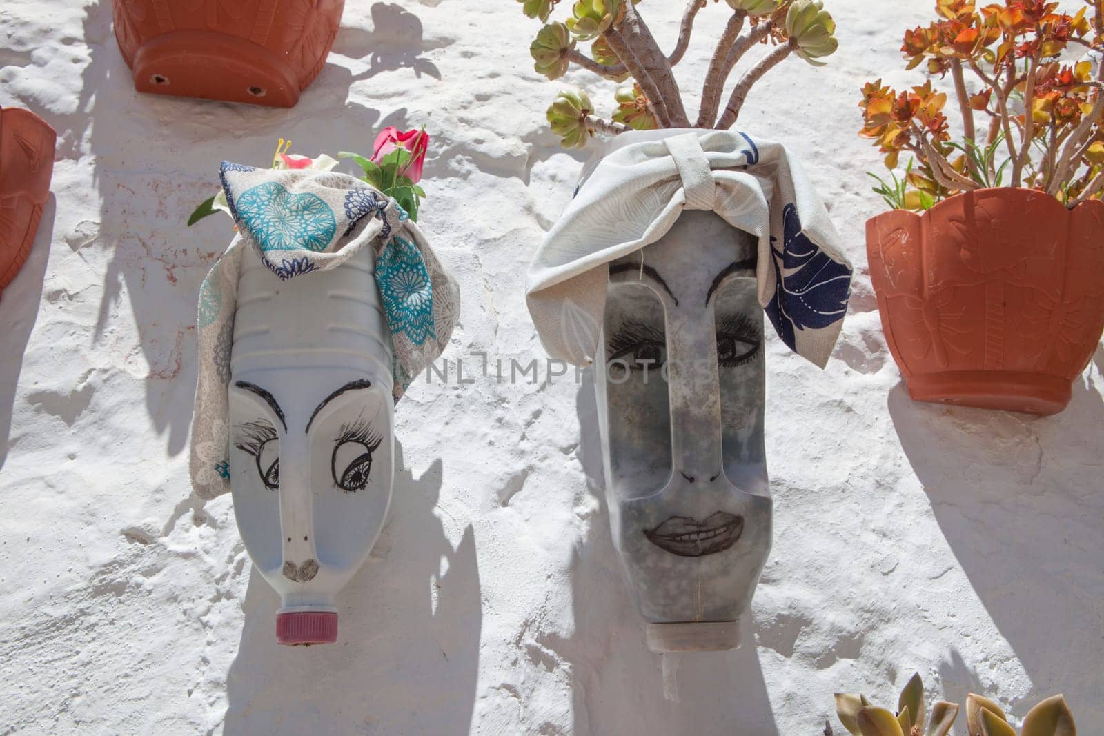 Detergent containers reused as flowerpot and attached on outdoor wall. Magacela Historical ensemble, Badajoz, Extremadura, Spain