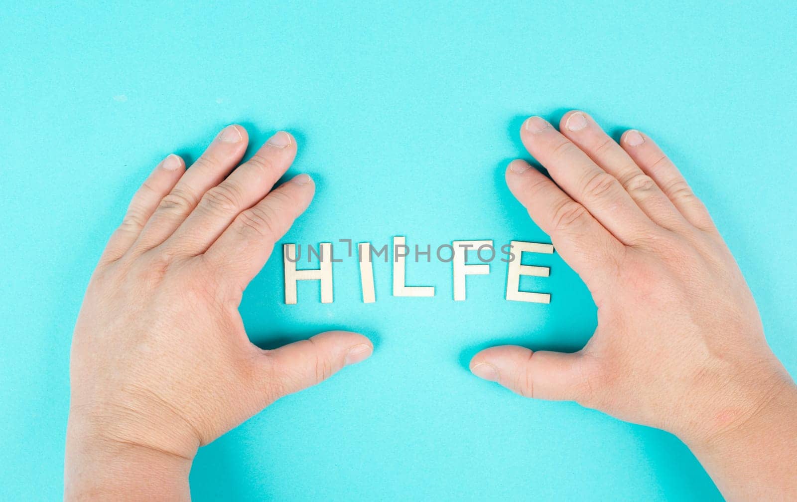 The word help stands in german language between the hands, giving support and charity