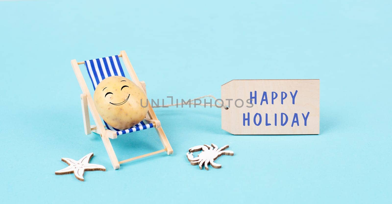 Potato with a funny face is sitting in lounge chairs, sign with the words happy holiday, greeting card