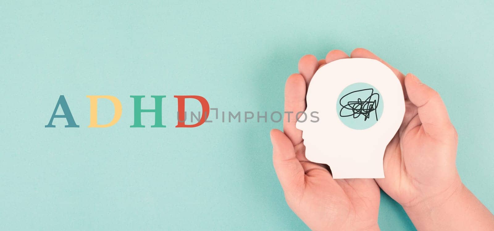Hands holding a silhouette of a human head, attention deficit hyperactivity disorder, ADHD symptom, mental health