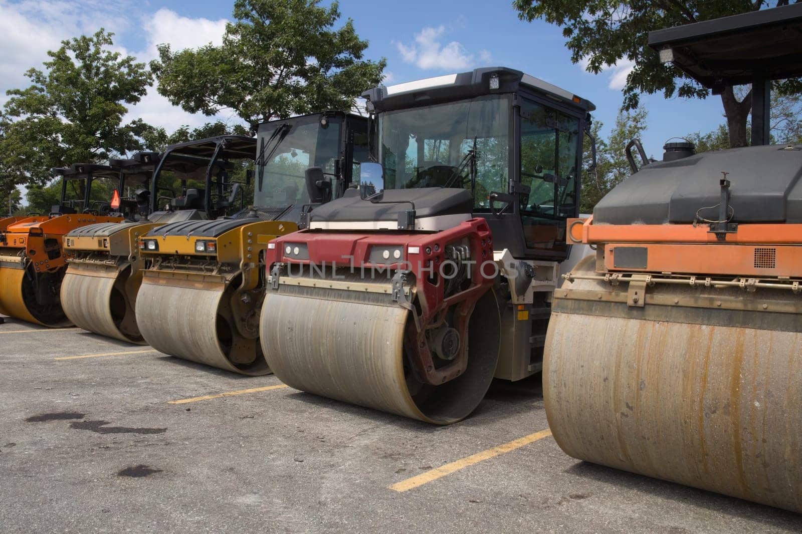 A row of steamrollers compactors on construction site road repair asphalt paving heavy equipment asphalting machines