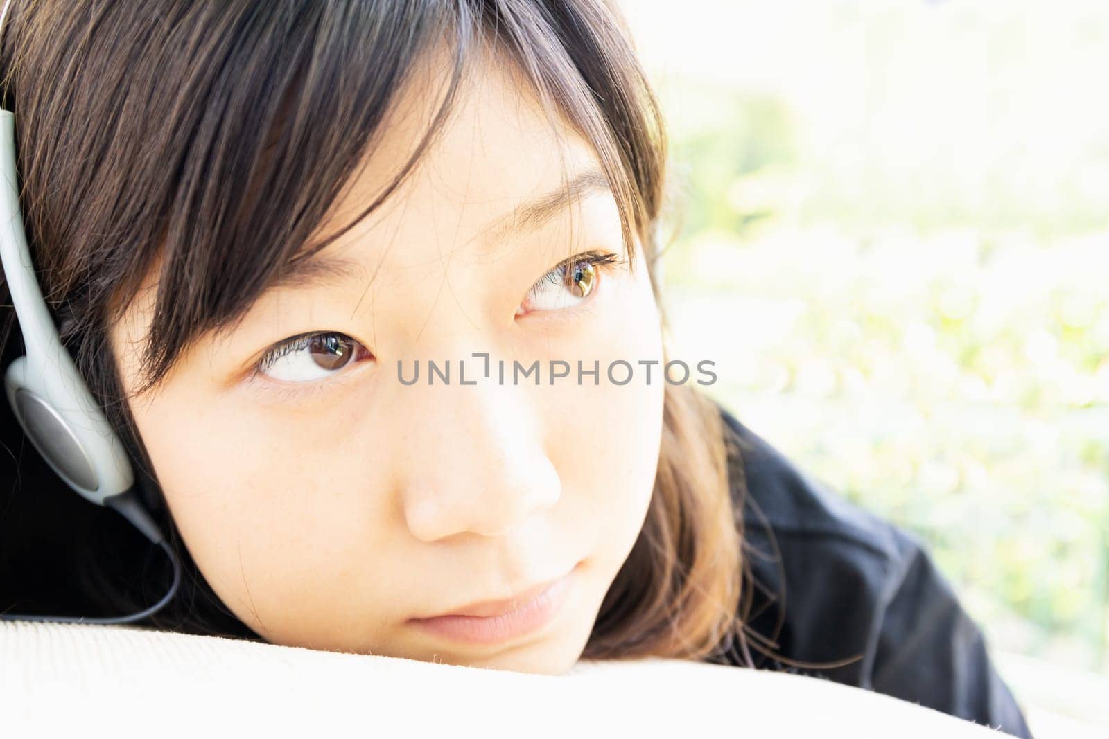 Teenage girl with headphones and listening to music from mobile phone at home