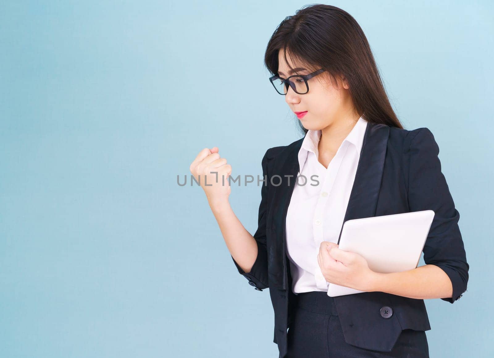 Young women standing in suit holding her digital tablet computor with finger pointing up