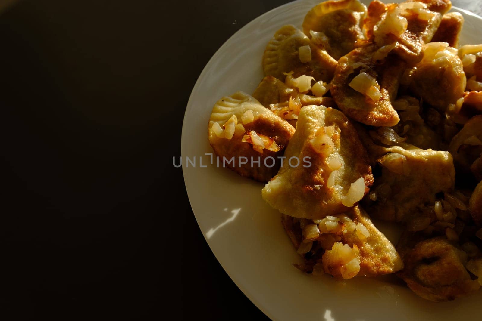 Homemade potato dumplings or vereniki pierogi, served with fried onions. Rustic style, comfort eastern europe cuisine.