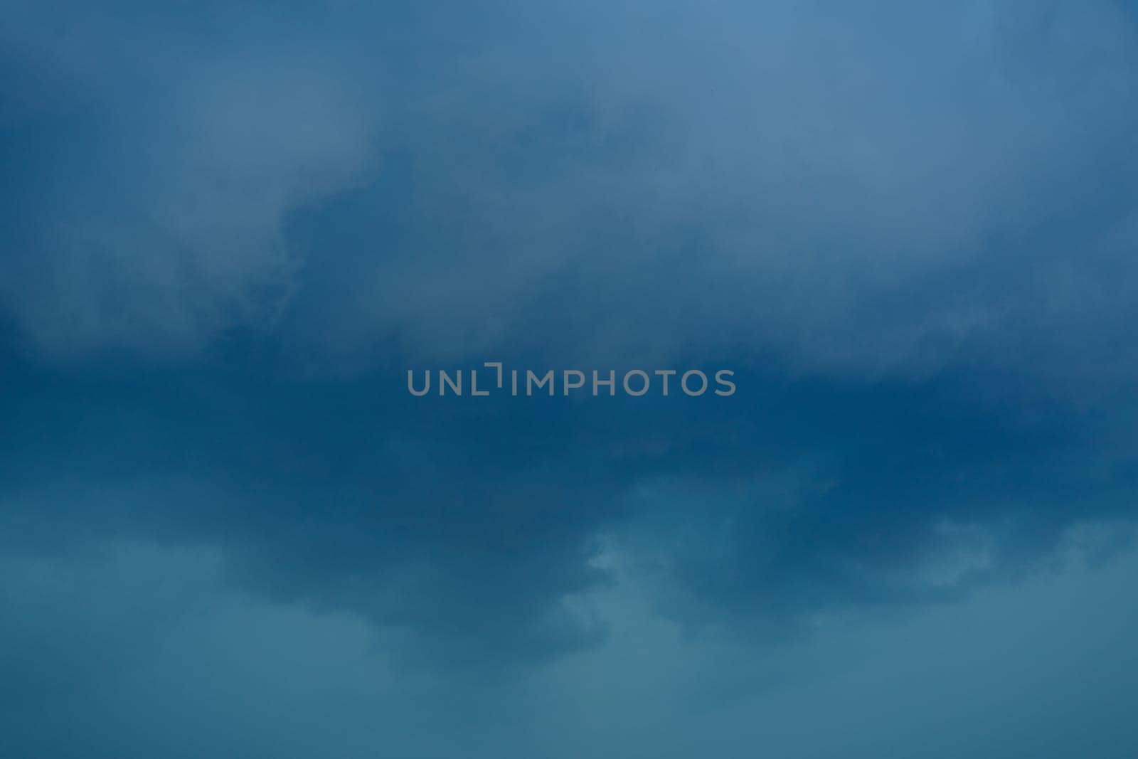dark storm clouds before rain storm in blue tones.