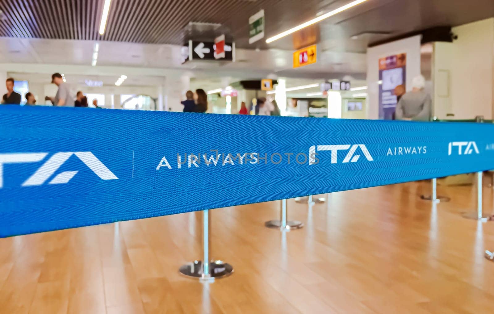 Rome, ITA, July 2022: blue belt barrier with white ITA Airways airlines logo. ITA Airways is the Italian flag carrier. Travel and airport security