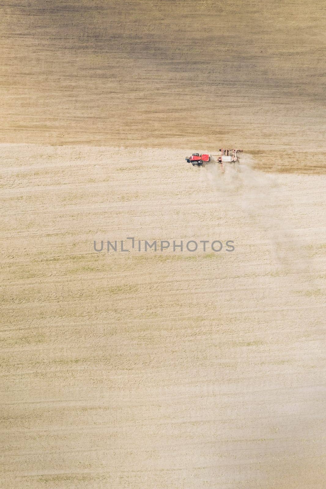 Aerial View. Tractor With Seed Drill Machine Sowing The Seeds For Crops In Spring Season. Beginning Of Agricultural Spring Season. Countryside Field Landscape. Natural Rural Background.