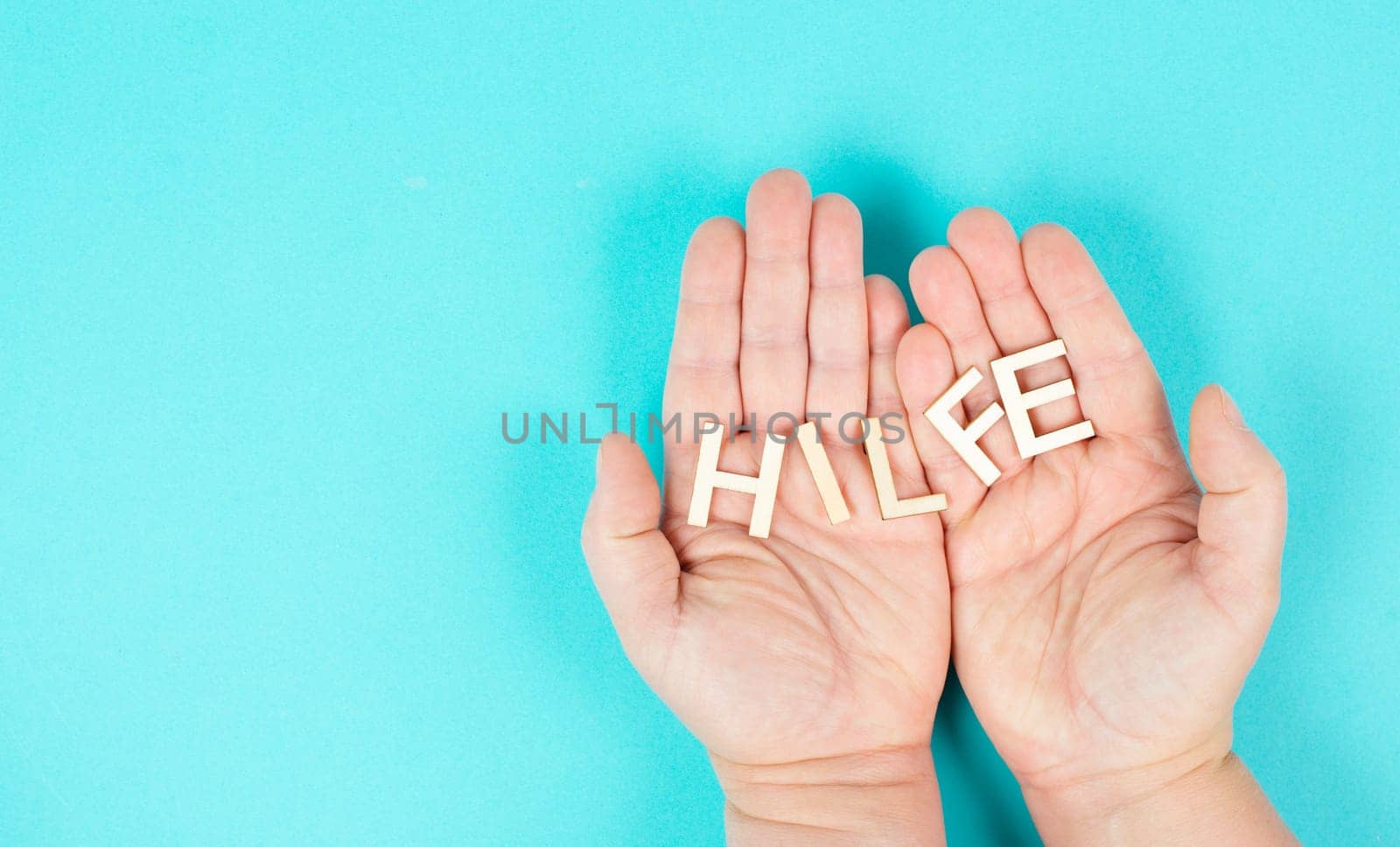 Holding the word help in the hands, german language, giving support and charity