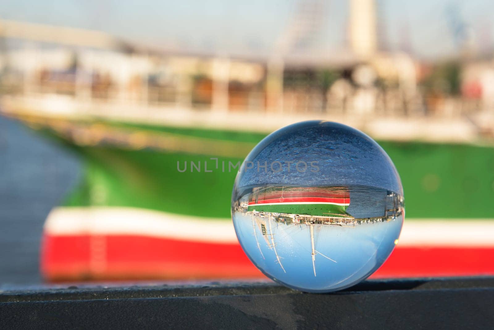 Fishing boats and old quays with the city view through lensball