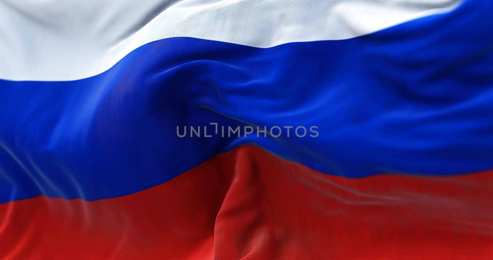 Close-up view of the Russian national flag waving in the wind. Russia is a transcontinental country spanning Eastern Europe and Northern Asia