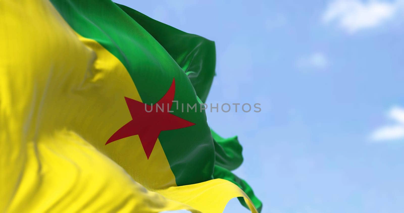 Flag of French Guiana waving in the wind on a clear day. French Guiana is an overseas department, region and single territorial collectivity of France