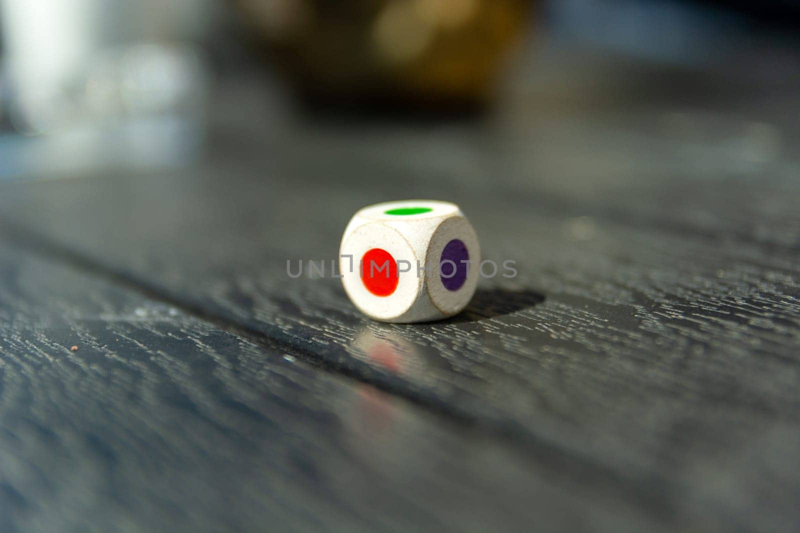 Dice with colored dots on the table, close up