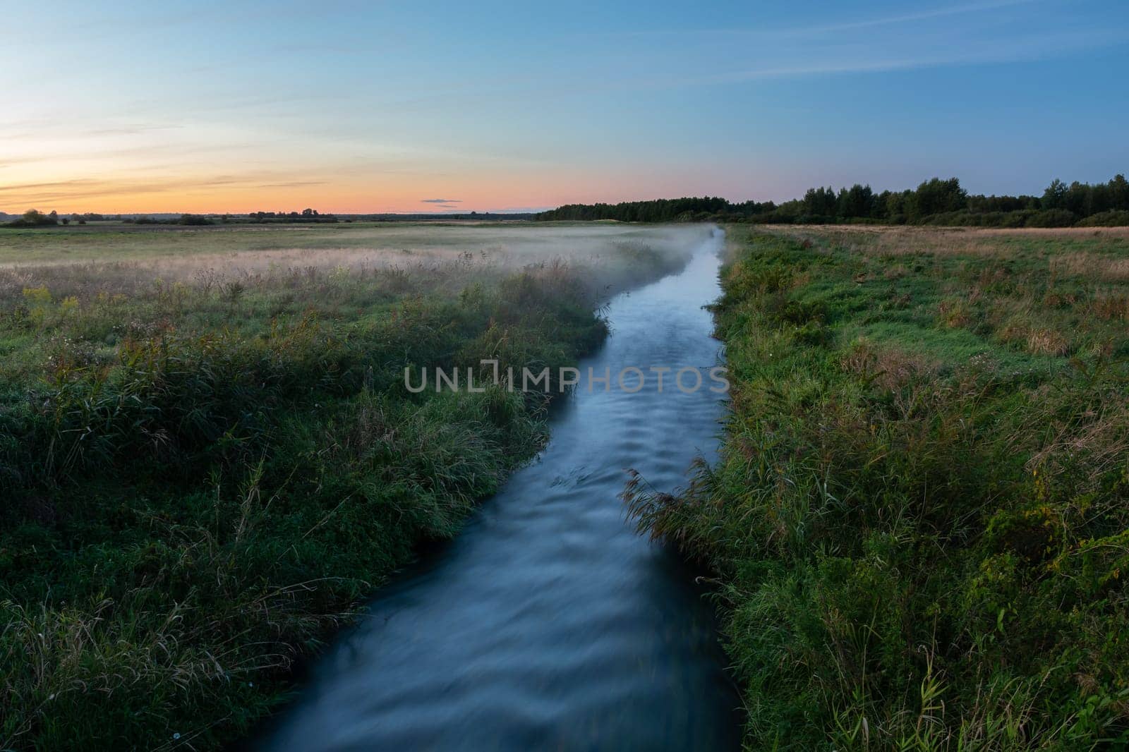 Small river and meadows with fog, view after sunset, Czulczyce, Poland