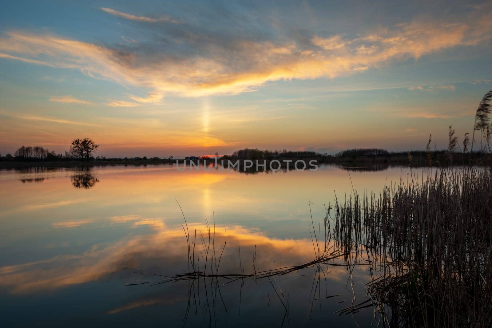 Reflection of the evening cloud in the lake water, spring evening