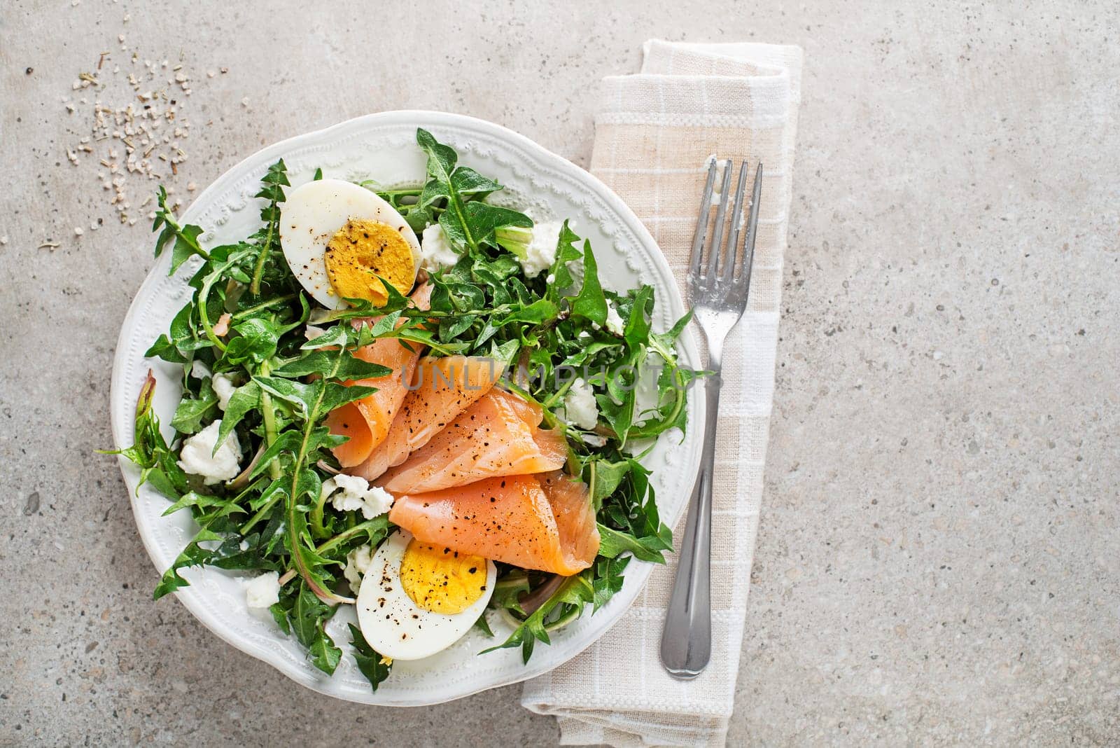 Salad with dandelion leaves smoked salmon, egg and fresh cheese
