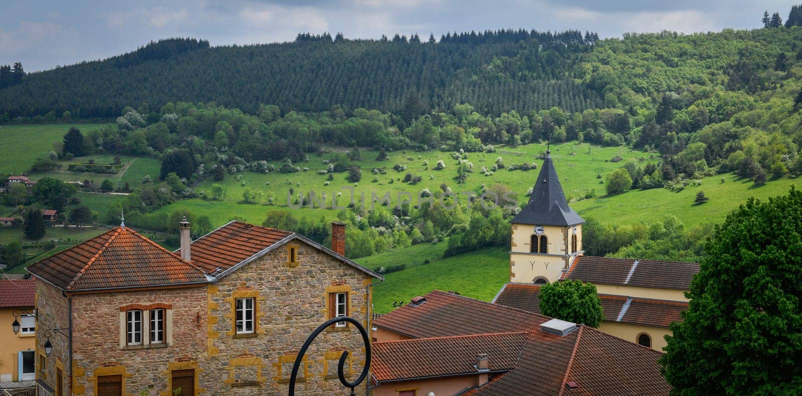 Typical village in the french countryside by spring with green grass and natural hills
