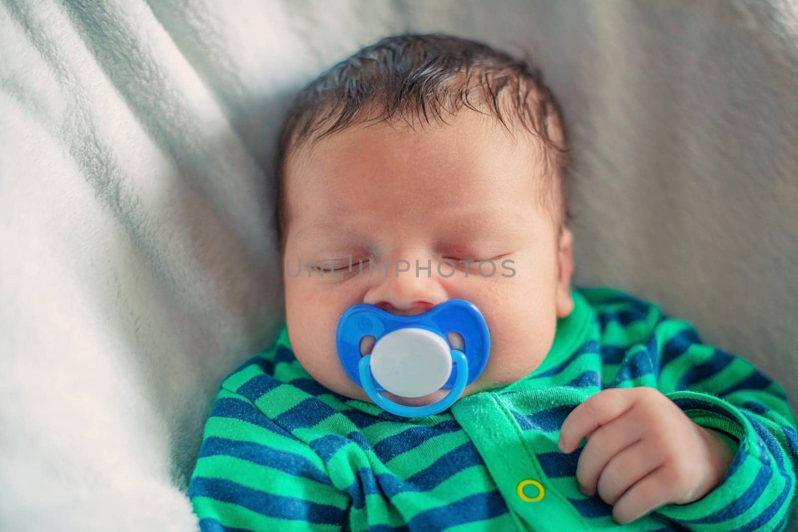 sleeping newborn baby with a pacifier in his mouth close-up