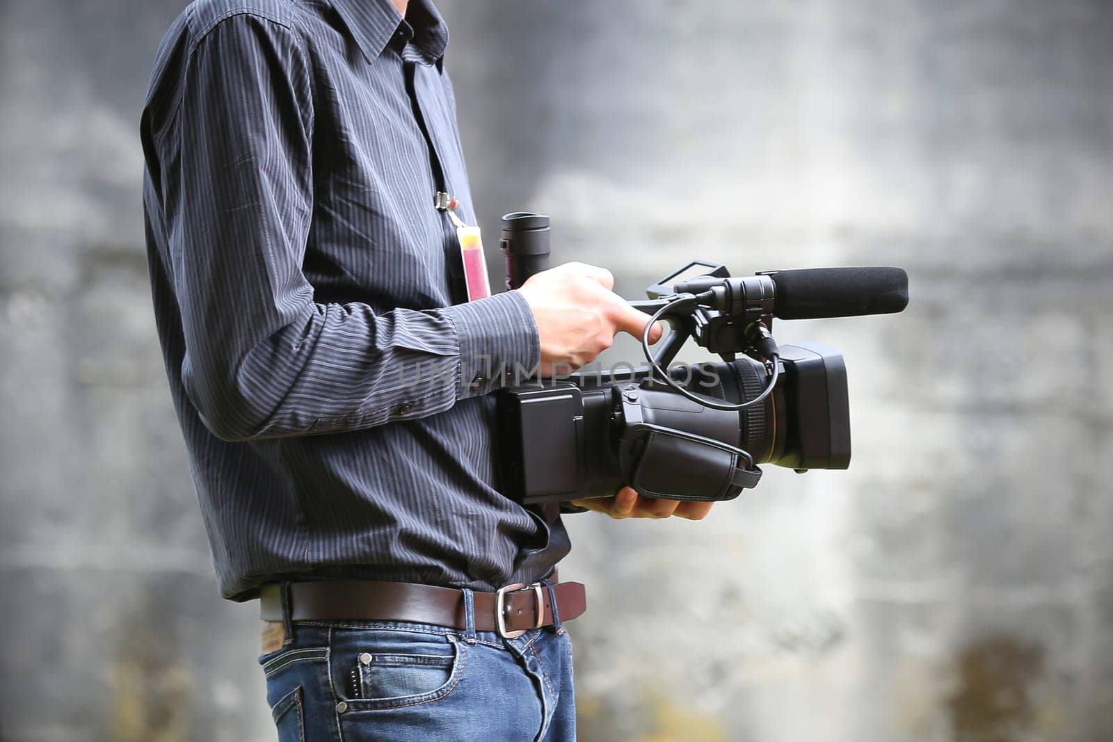 Video camera man with camera on gray background