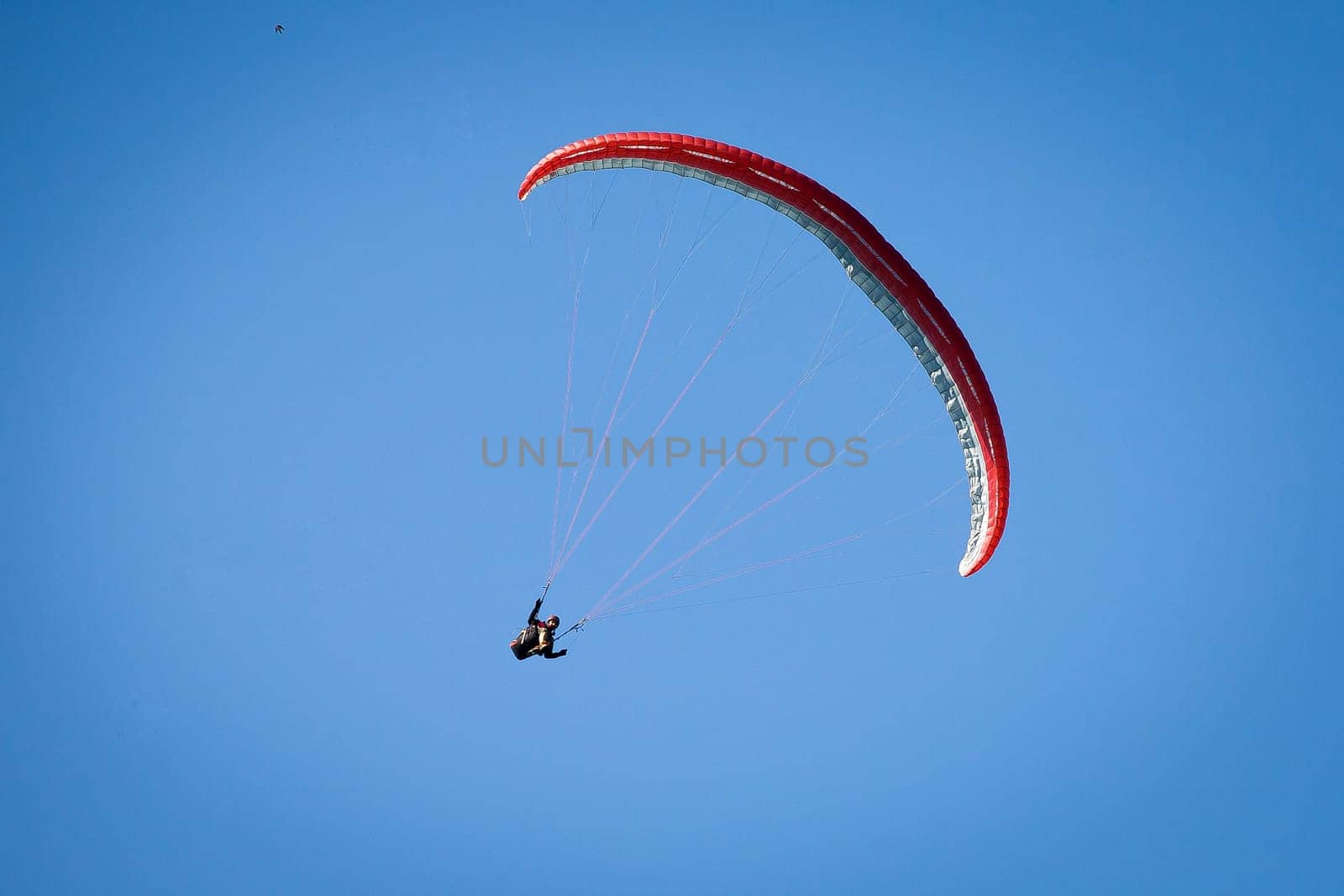 Paraglider, airborne in a clear blue sky