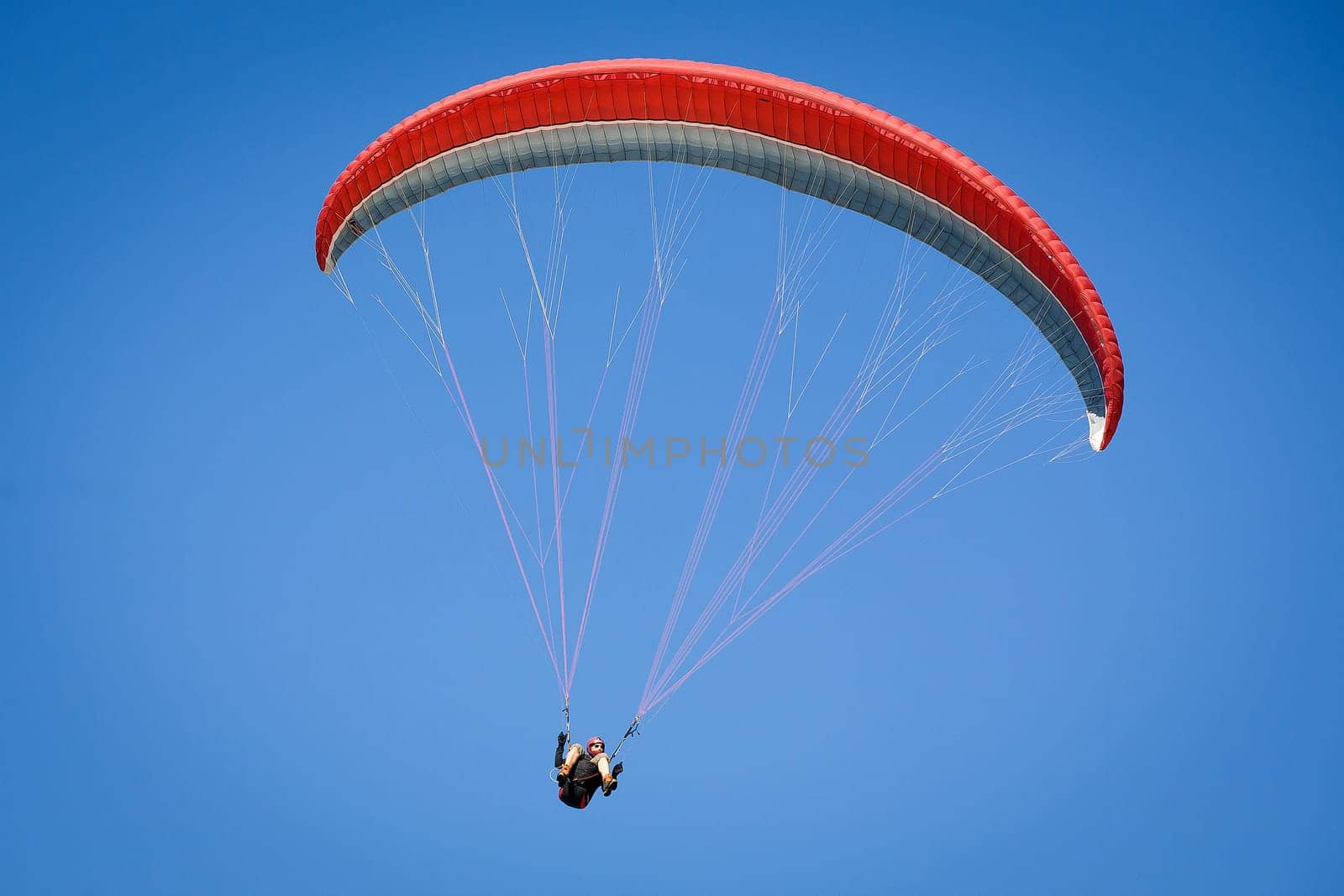 Paraglider, airborne in a clear blue sky