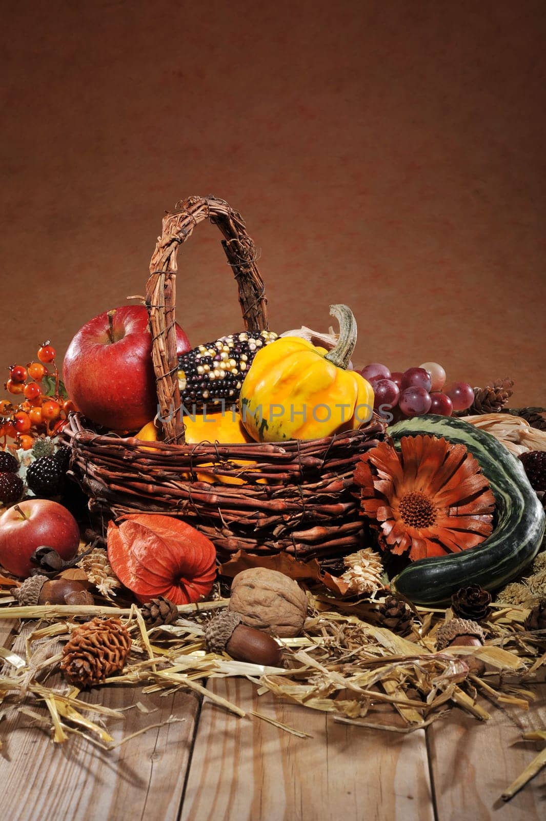 Pumpkins,apples,nuts,berries,corn and cereals with basket on old weathered wooden boards