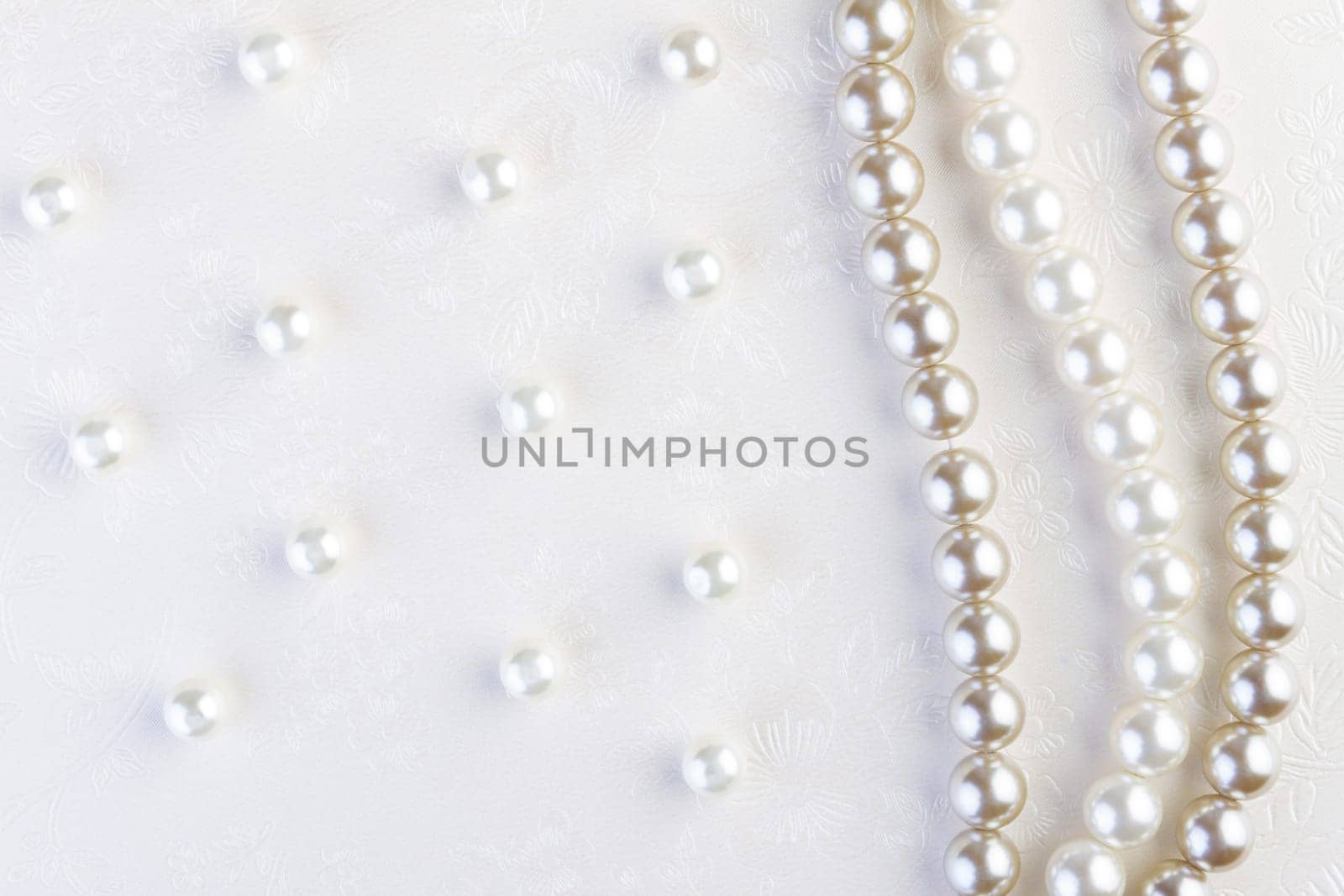 White pearls necklace on white paper background
