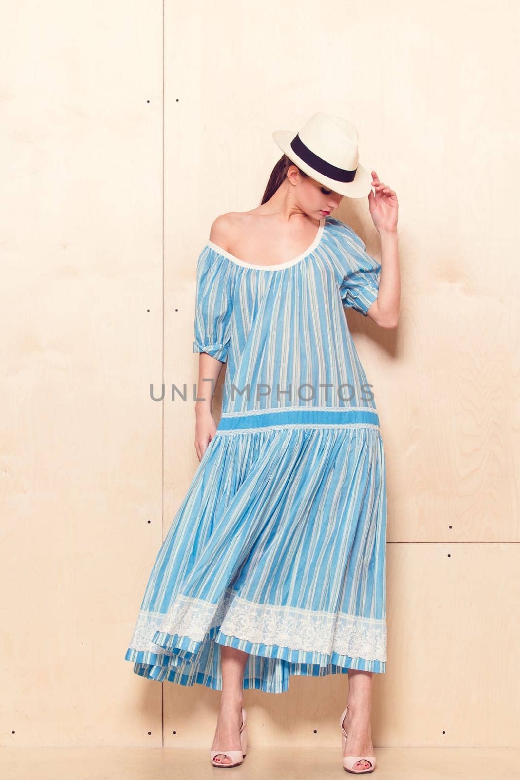 Full-length portrait of a lovely woman in romantic dress on wodden background