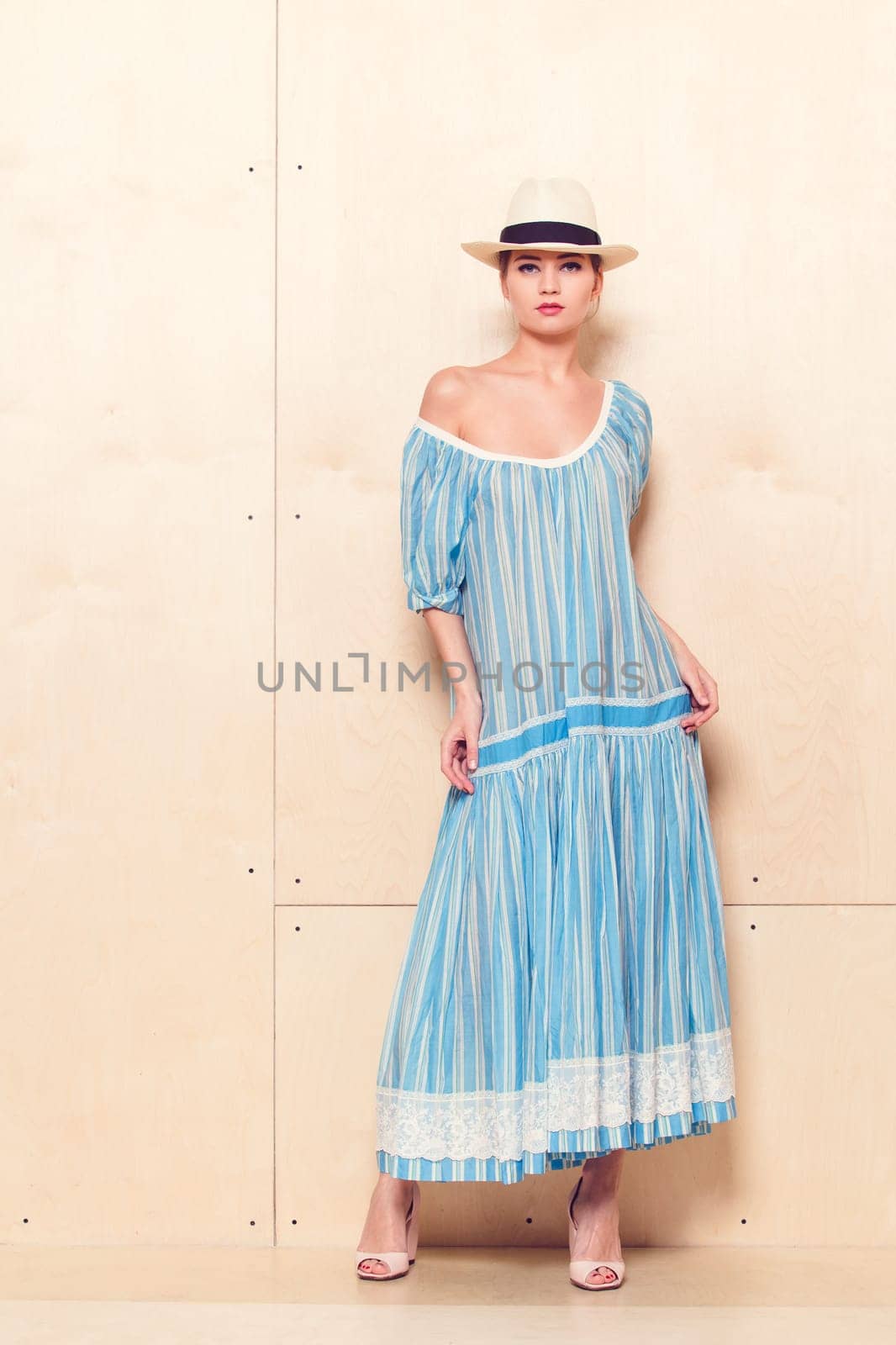 Full-length portrait of a lovely woman in romantic dress on wodden background