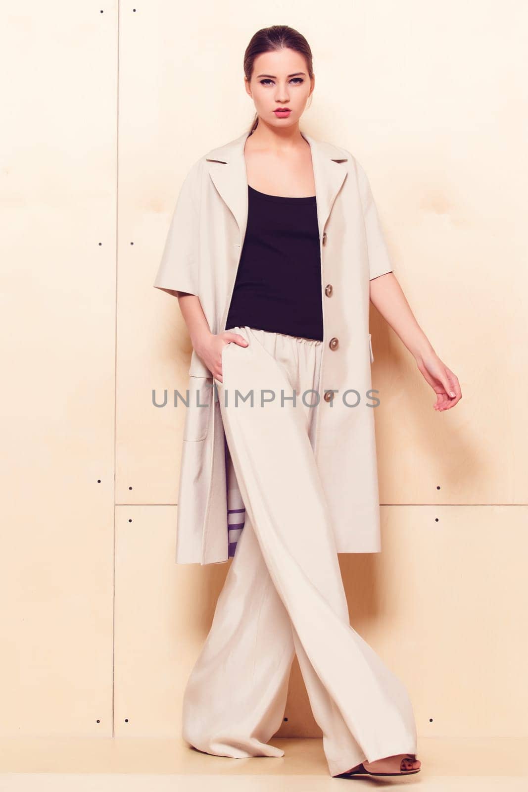 Full height portrait of a young woman in a bright pantsuit