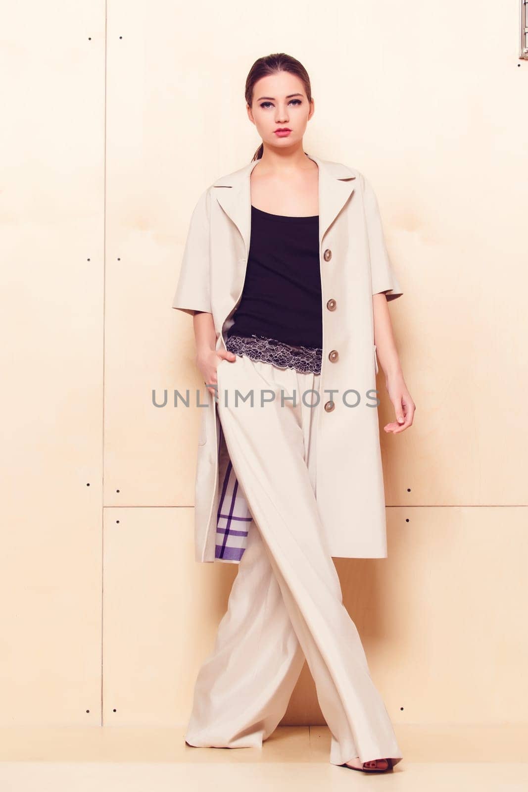 Full height portrait of a young woman in a bright pantsuit
