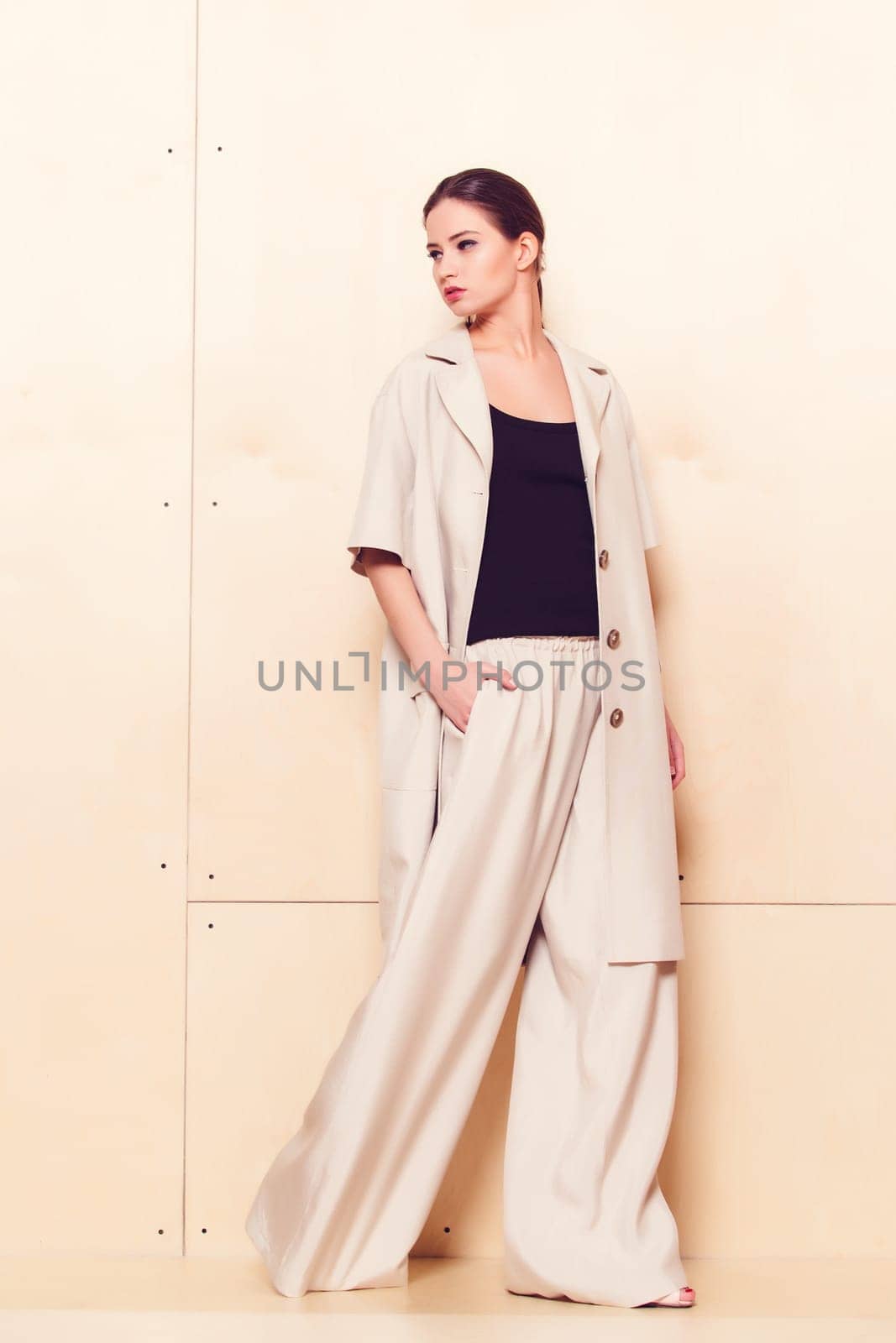 Full height portrait of a young woman in a bright pantsuit