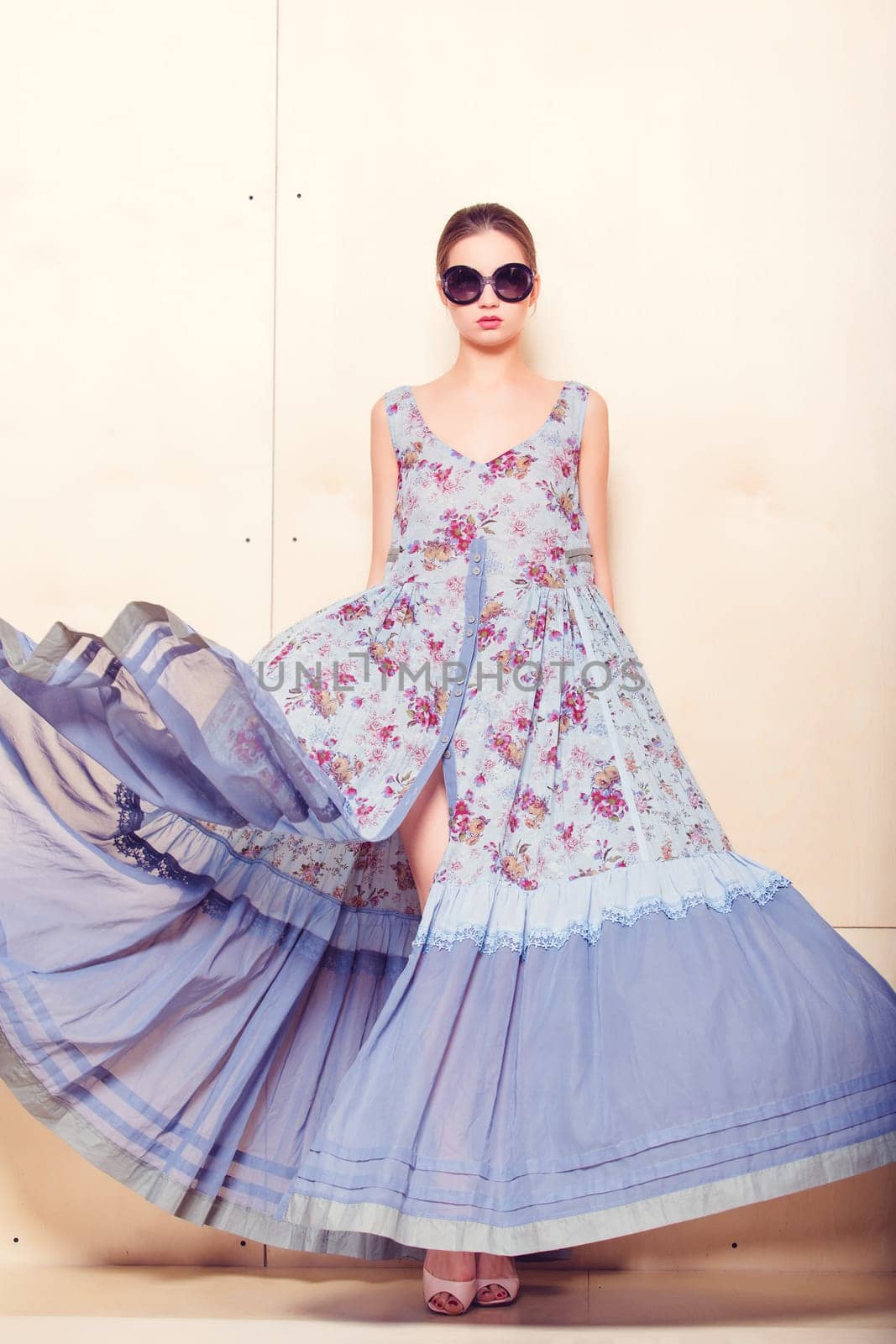 Full-length portrait of a lovely woman in romantic dress on wodden background