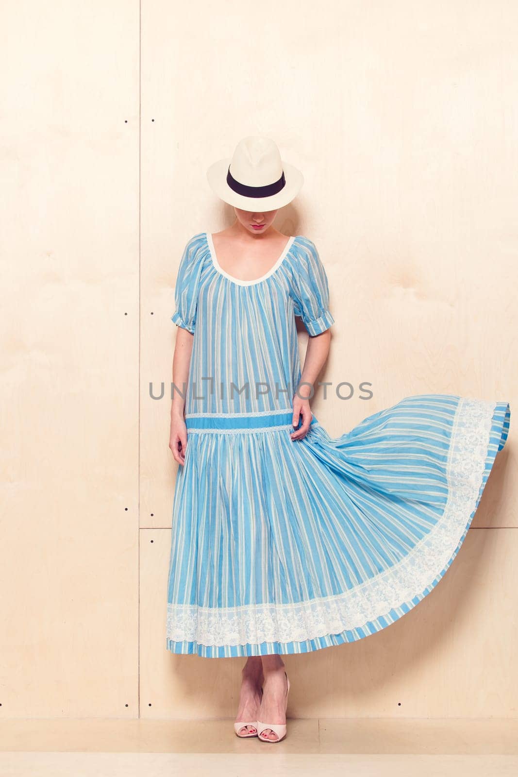 Full-length portrait of a lovely woman in romantic dress on wodden background