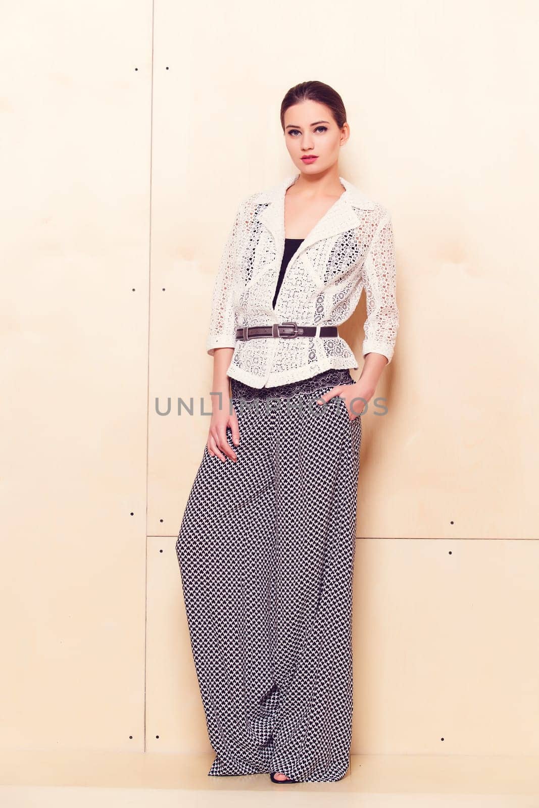Full height portrait of a young woman in a bright pantsuit
