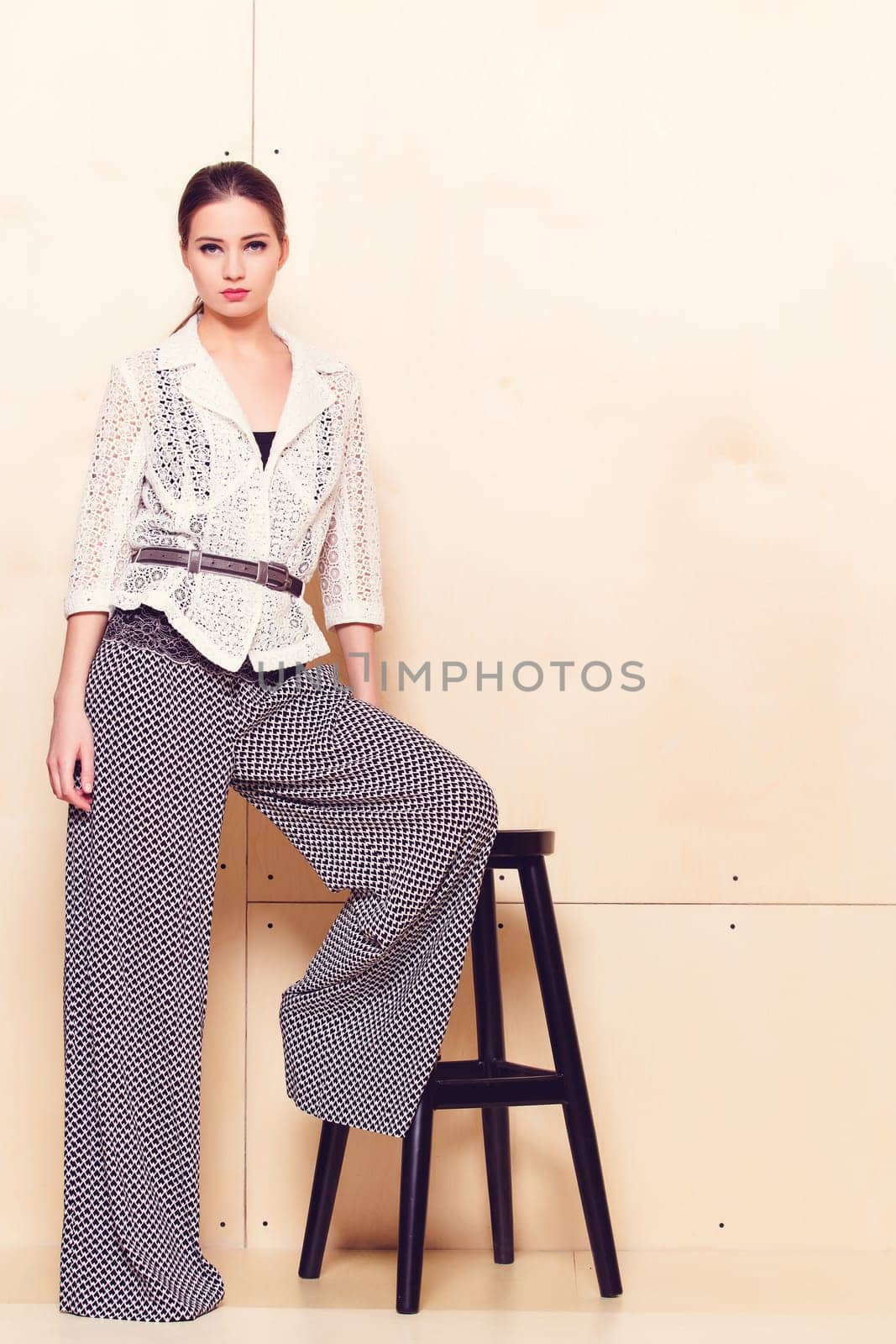 Full height portrait of a young woman in a bright pantsuit
