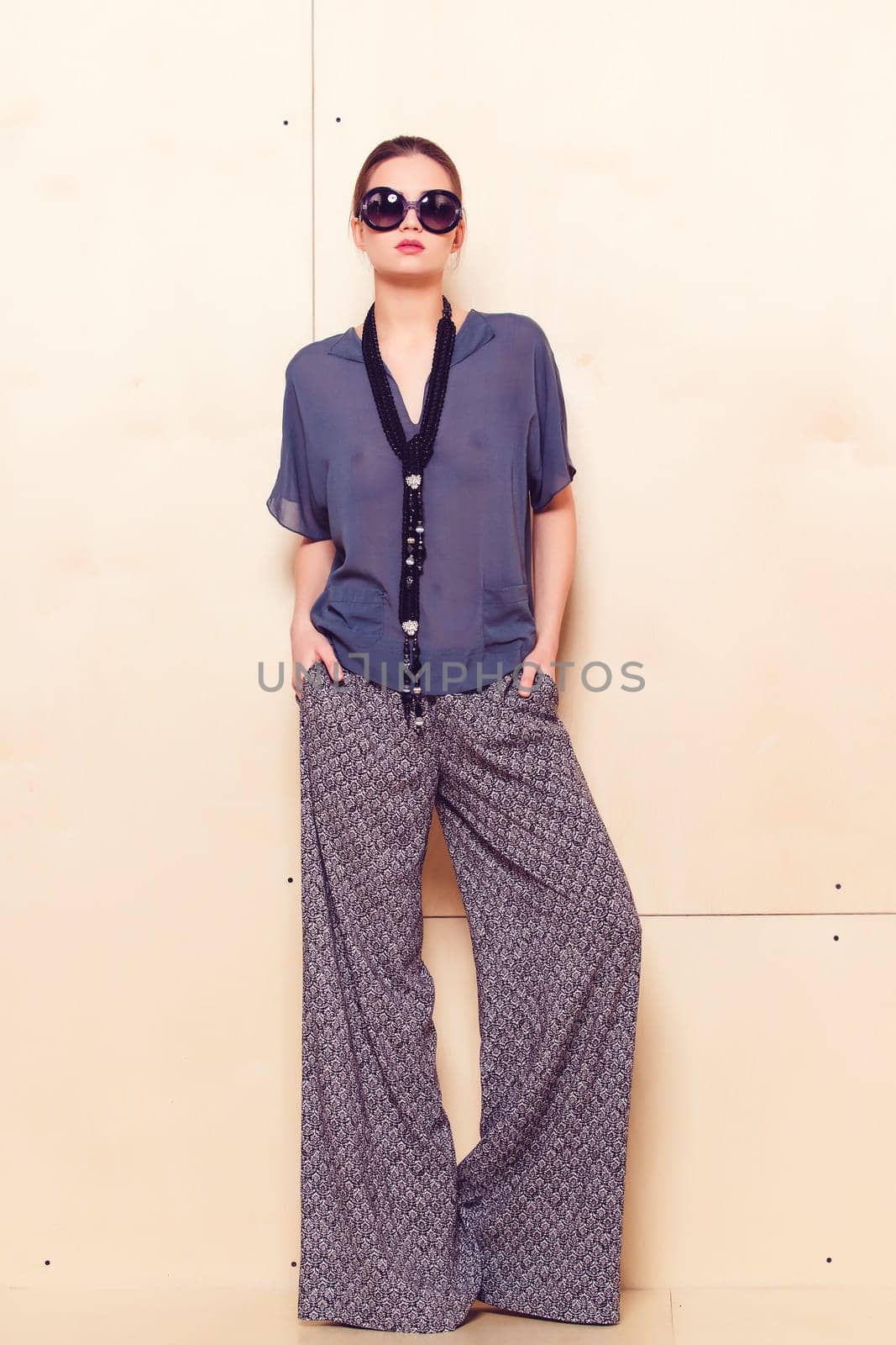 Full height portrait of a young woman in a bright pantsuit