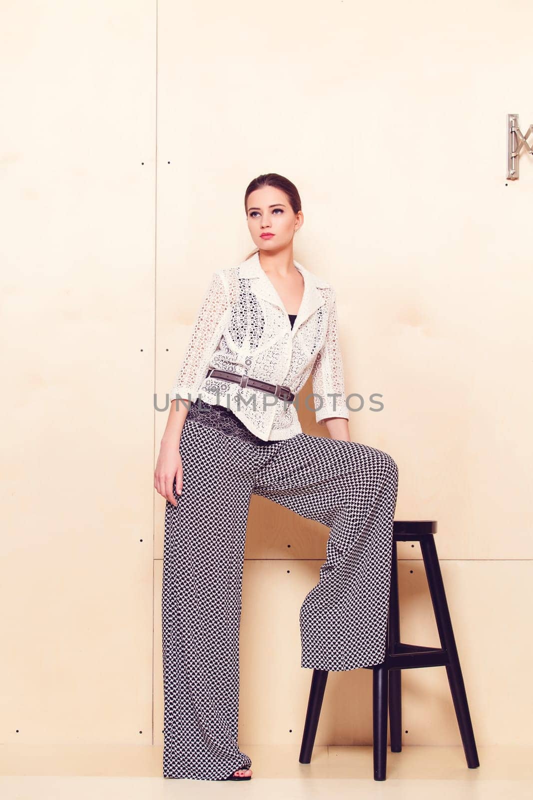 Full height portrait of a young woman in a bright pantsuit