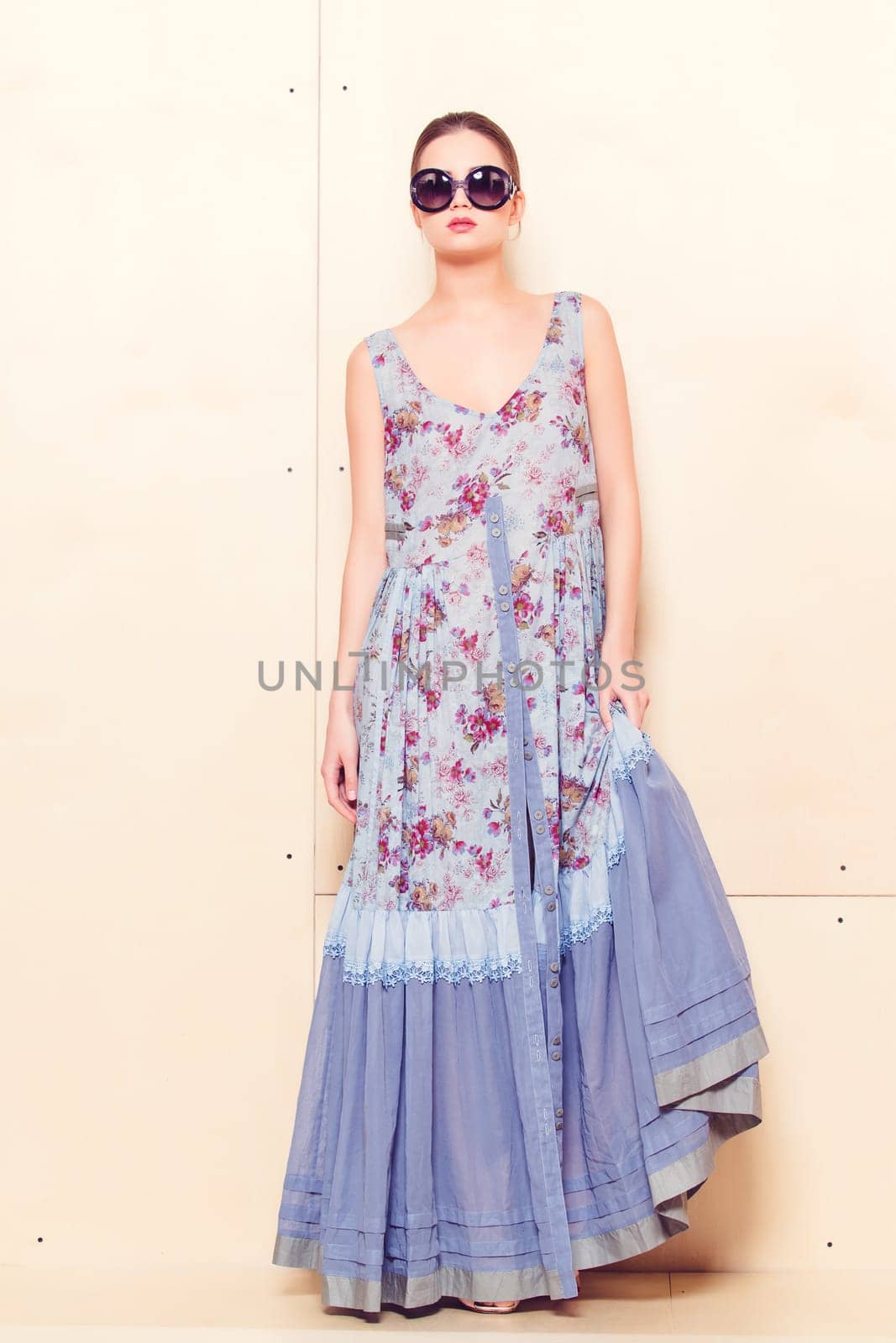 Full-length portrait of a lovely woman in romantic dress on wodden background