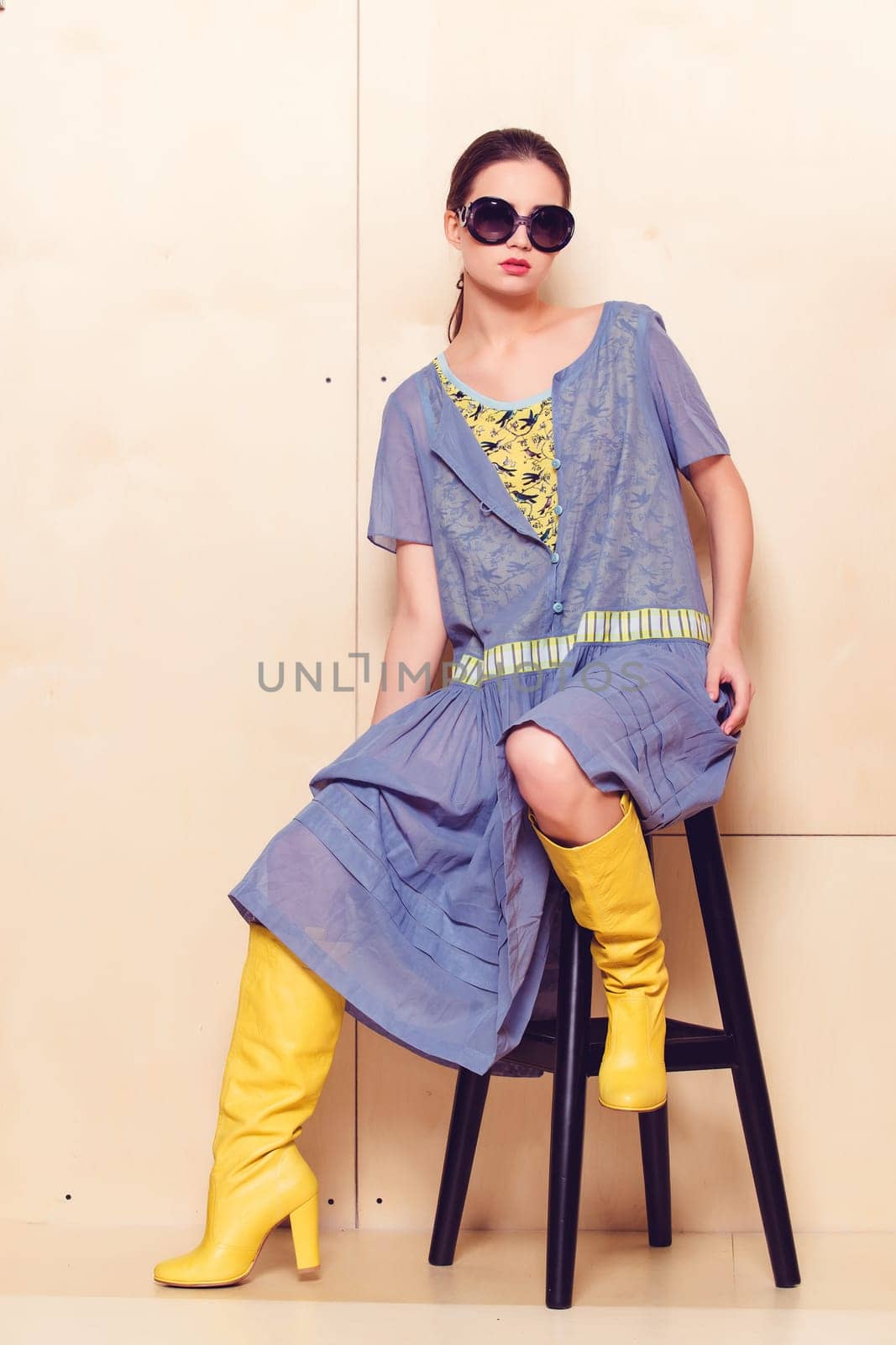 Full body slim woman in blue sundress on wooden background