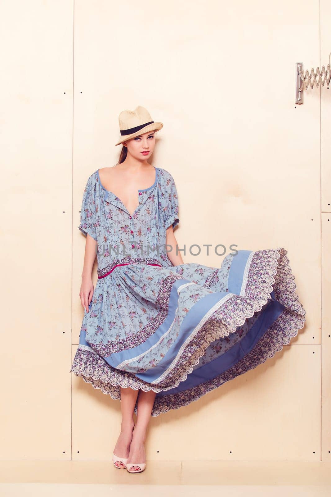 Full body slim woman in blue sundress on wooden background