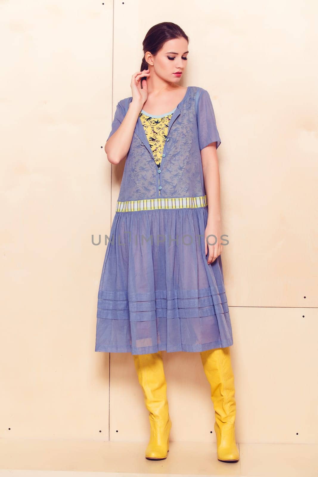 Full body slim woman in blue sundress on wooden background