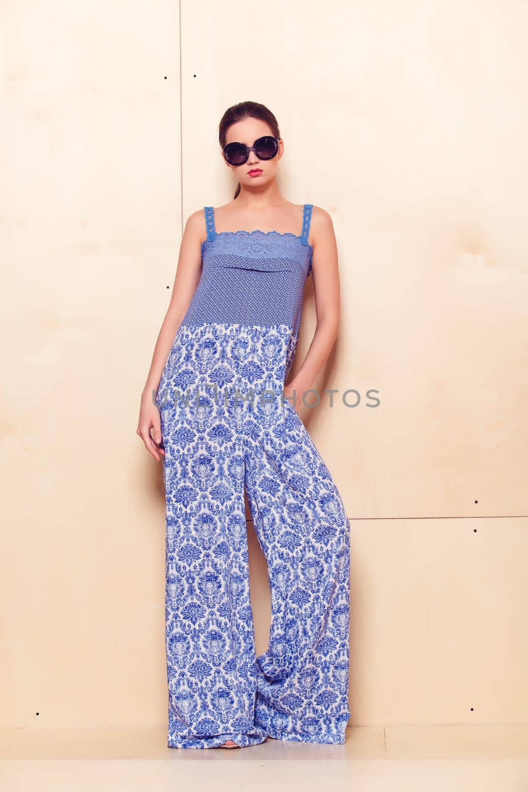 Full height portrait of a young woman in a bright pantsuit