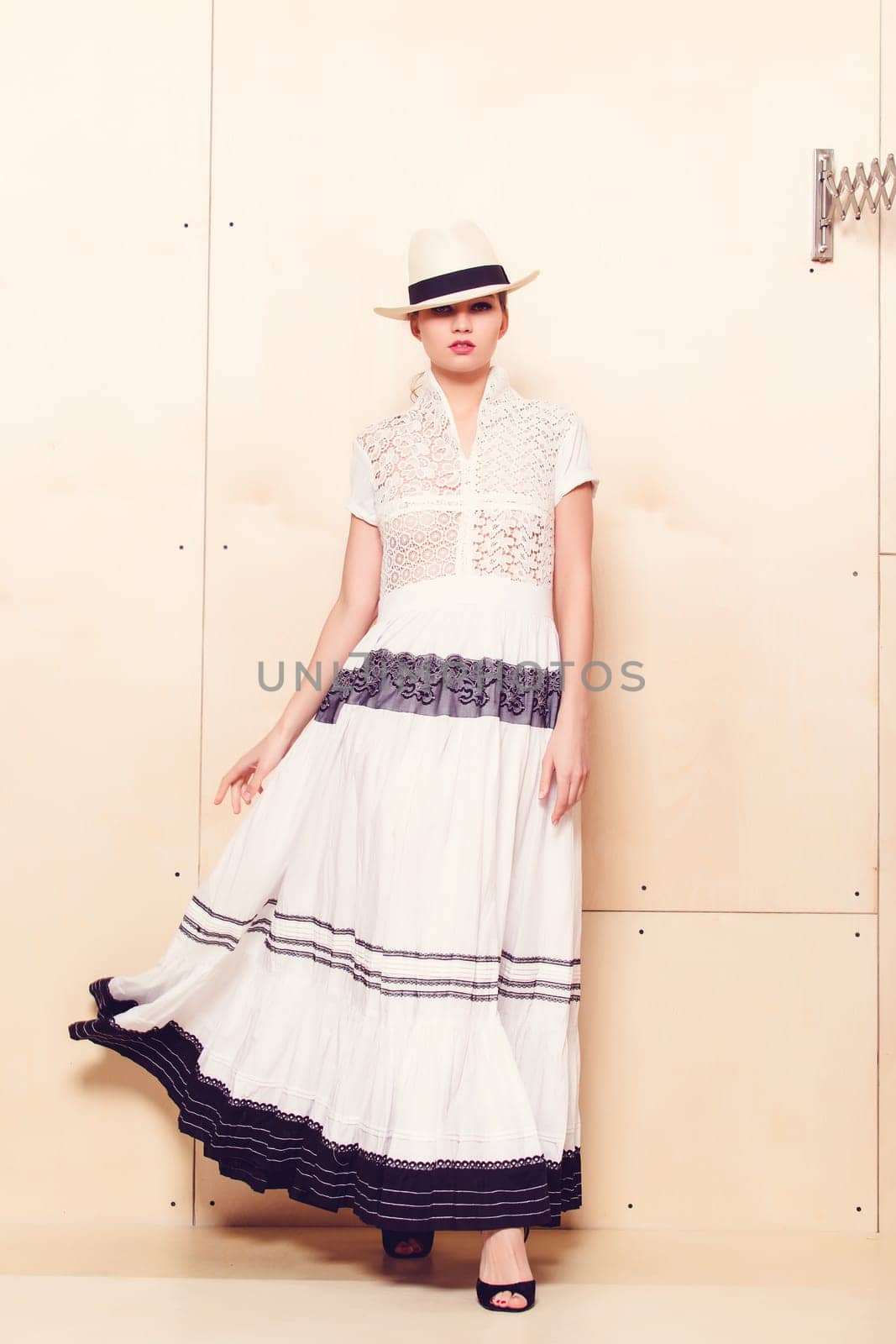 Full-length portrait of a lovely woman in romantic dress on wodden background