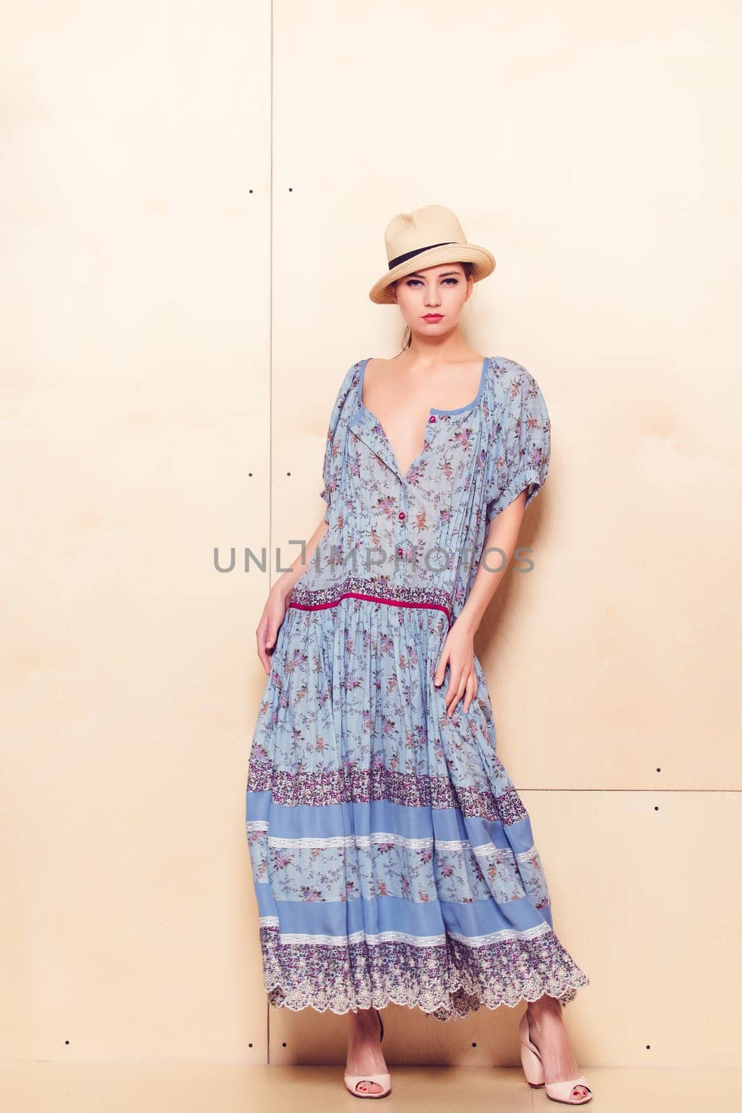 Full-length portrait of a lovely woman in romantic dress on wodden background