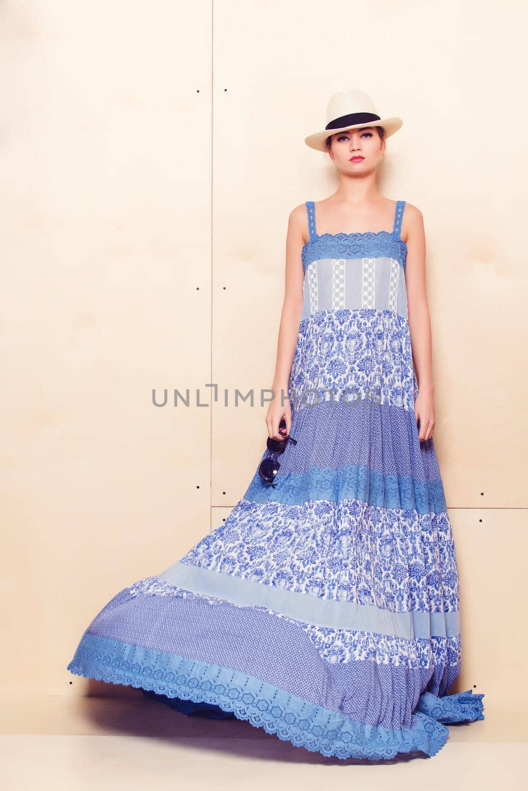 Full-length portrait of a lovely woman in romantic dress on wodden background