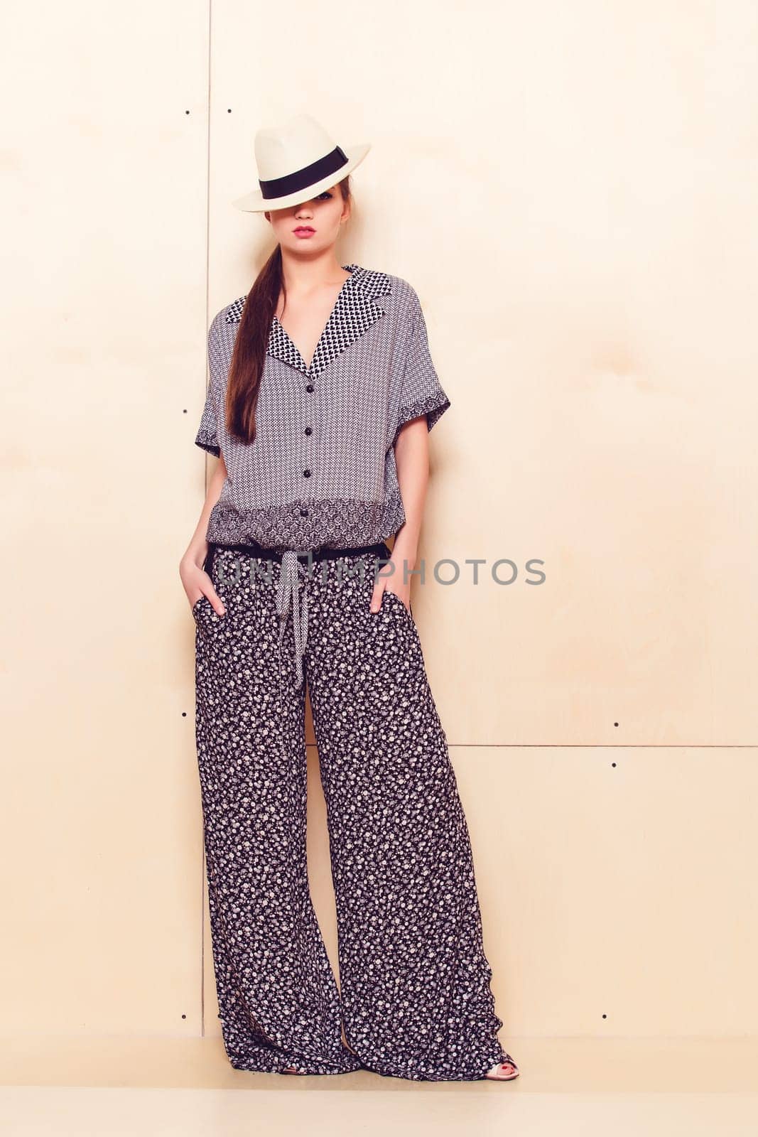 Full height portrait of a young woman in a bright pantsuit