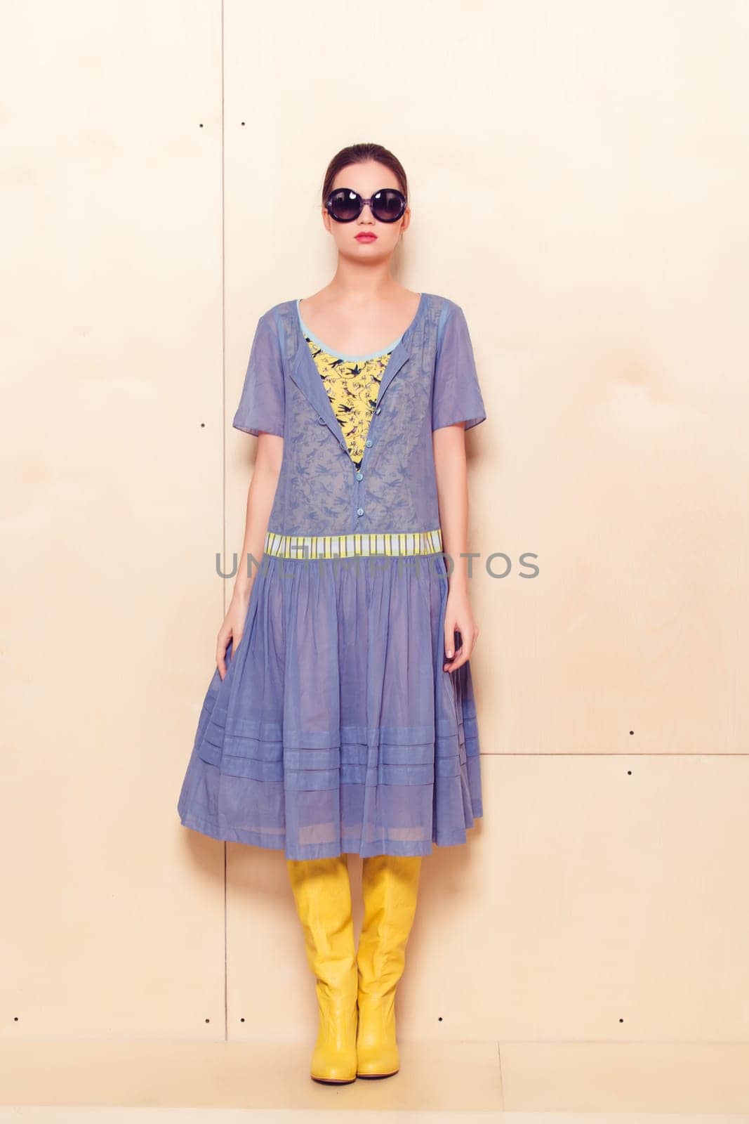Full body slim woman in blue sundress on wooden background